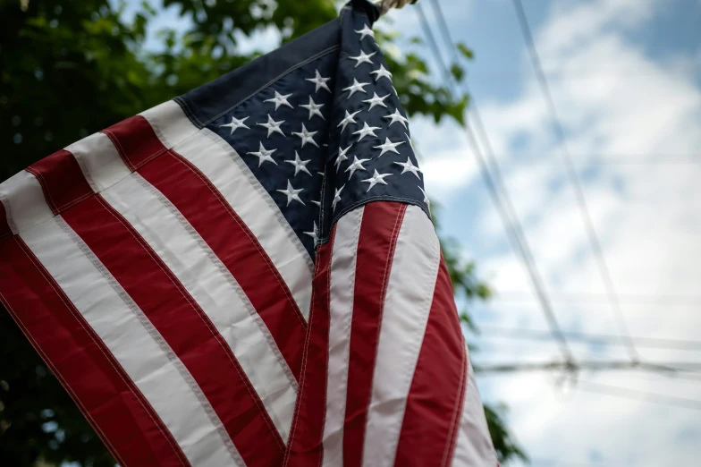 an american flag hangs from a power pole