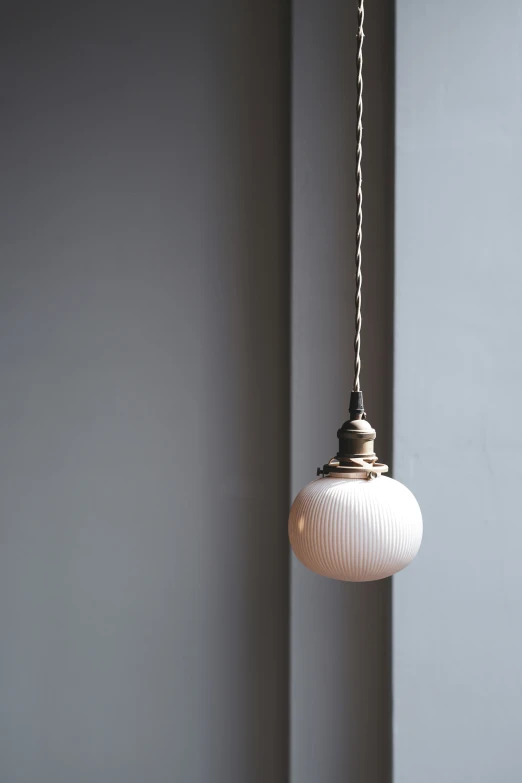 a hanging light fixture with a white glass ball
