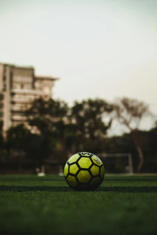 a soccer ball in the grass at an empty field