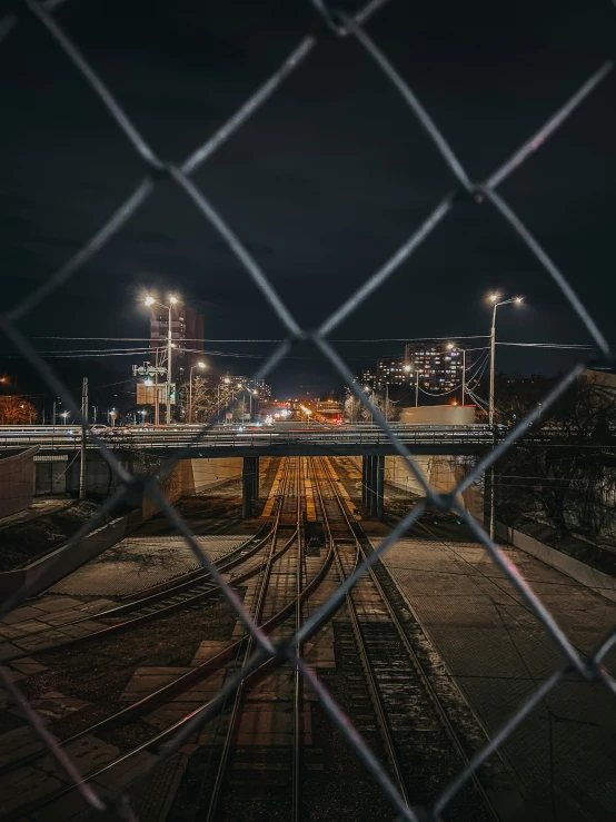 view of train tracks through chain link fence