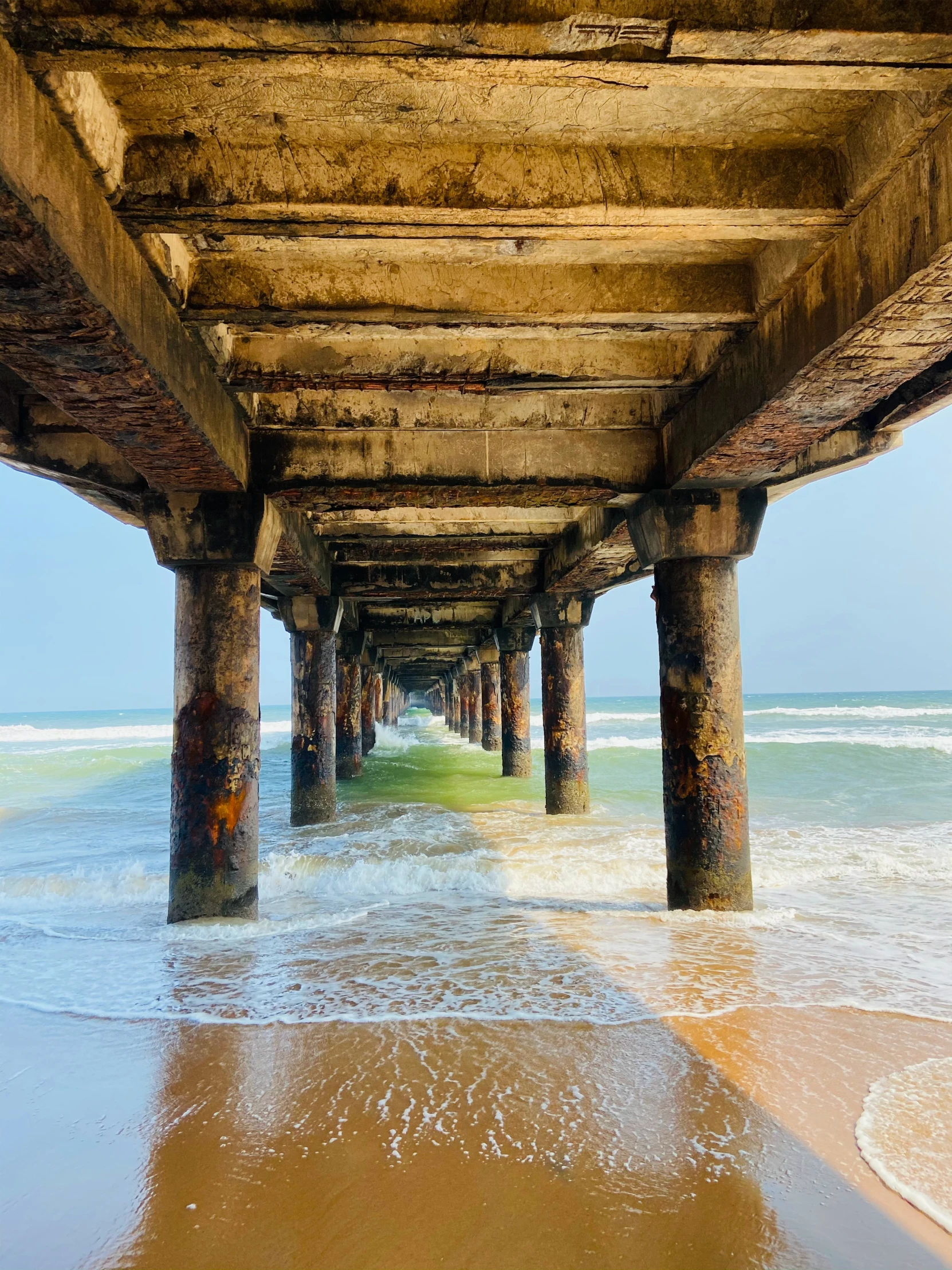 a row of posts with ocean below at beach