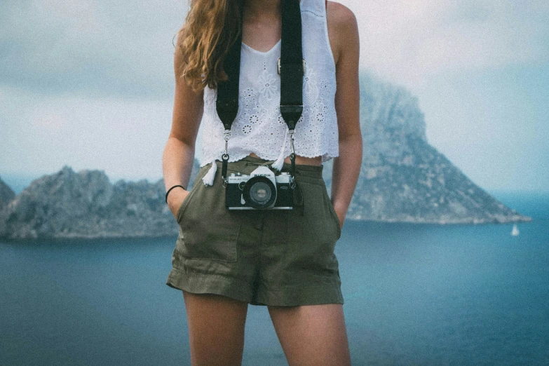 a person in a hat and shorts with a camera