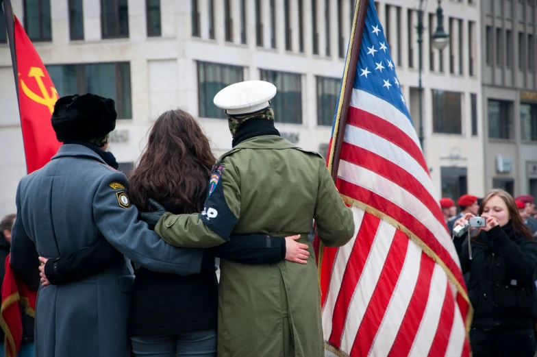 two people with a usa flag hug next to flags