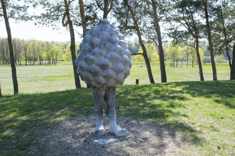 a sculpture in the shape of a plant is seen next to some trees
