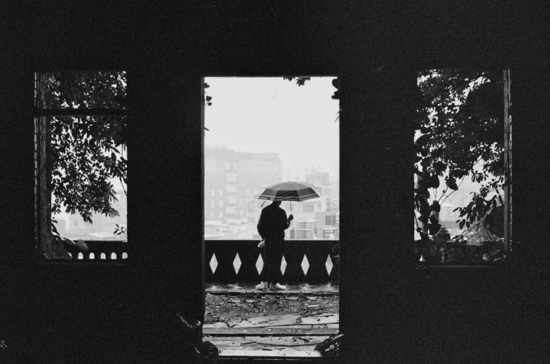 a black and white po of people in a room holding umbrella