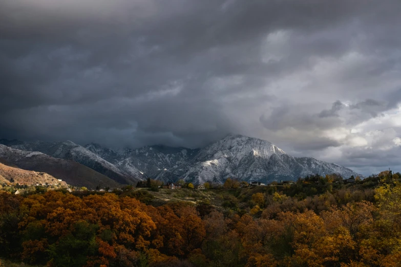 a view of mountains and clouds over trees