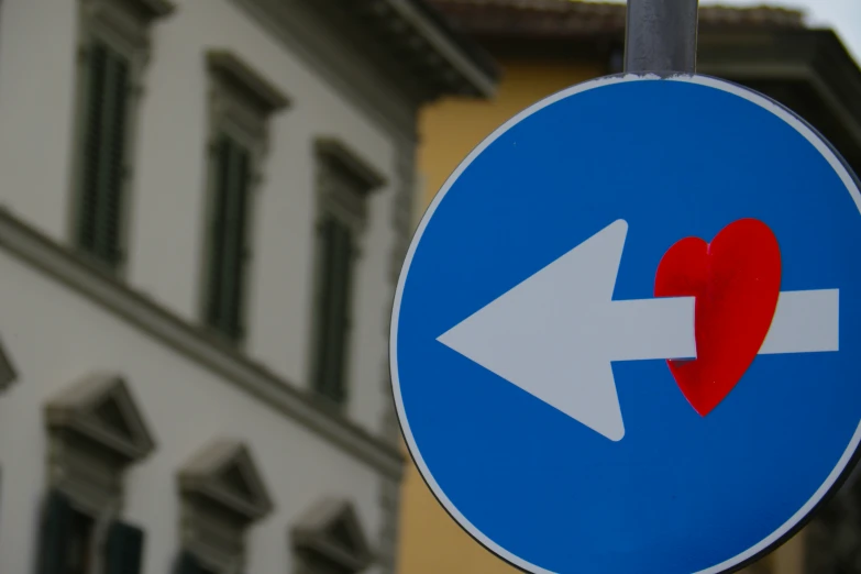 a sign with an arrow and a heart painted on it