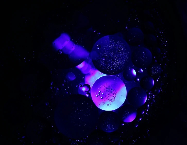 a group of black balls in a blue and pink light