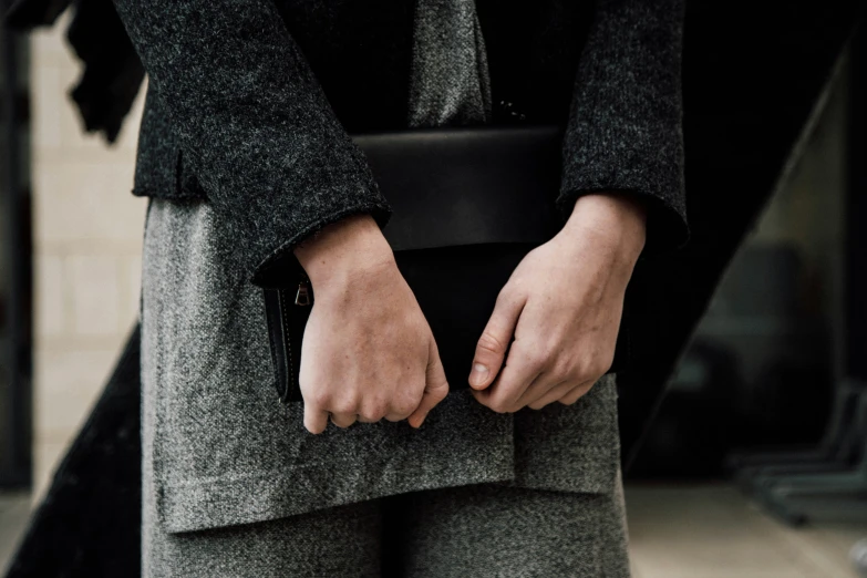 person holding black briefcase in dark gray coat