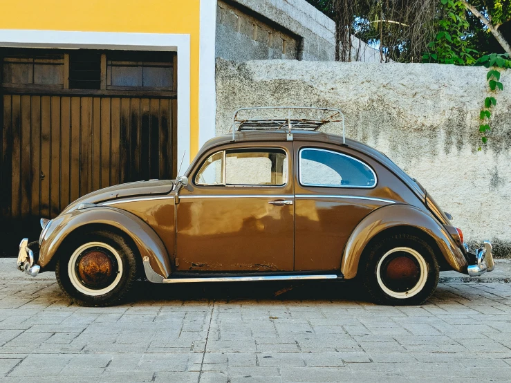 an old car parked outside a garage with its roof rack removed