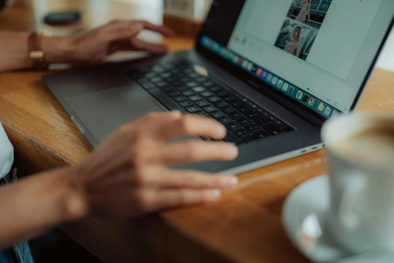 a person using their cell phone on a laptop