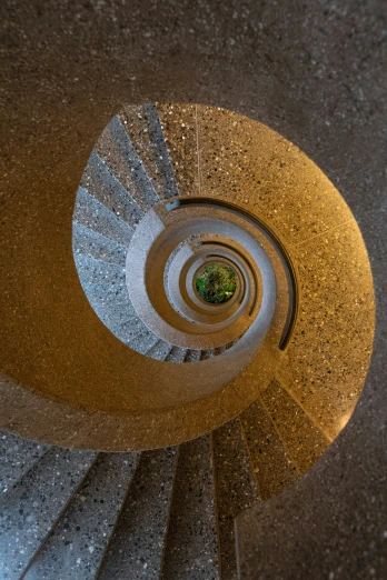 view down the spiral staircase with sunlight coming through the center