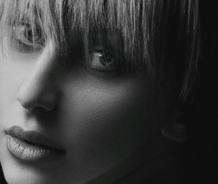 a close up black and white po of a woman with bangs