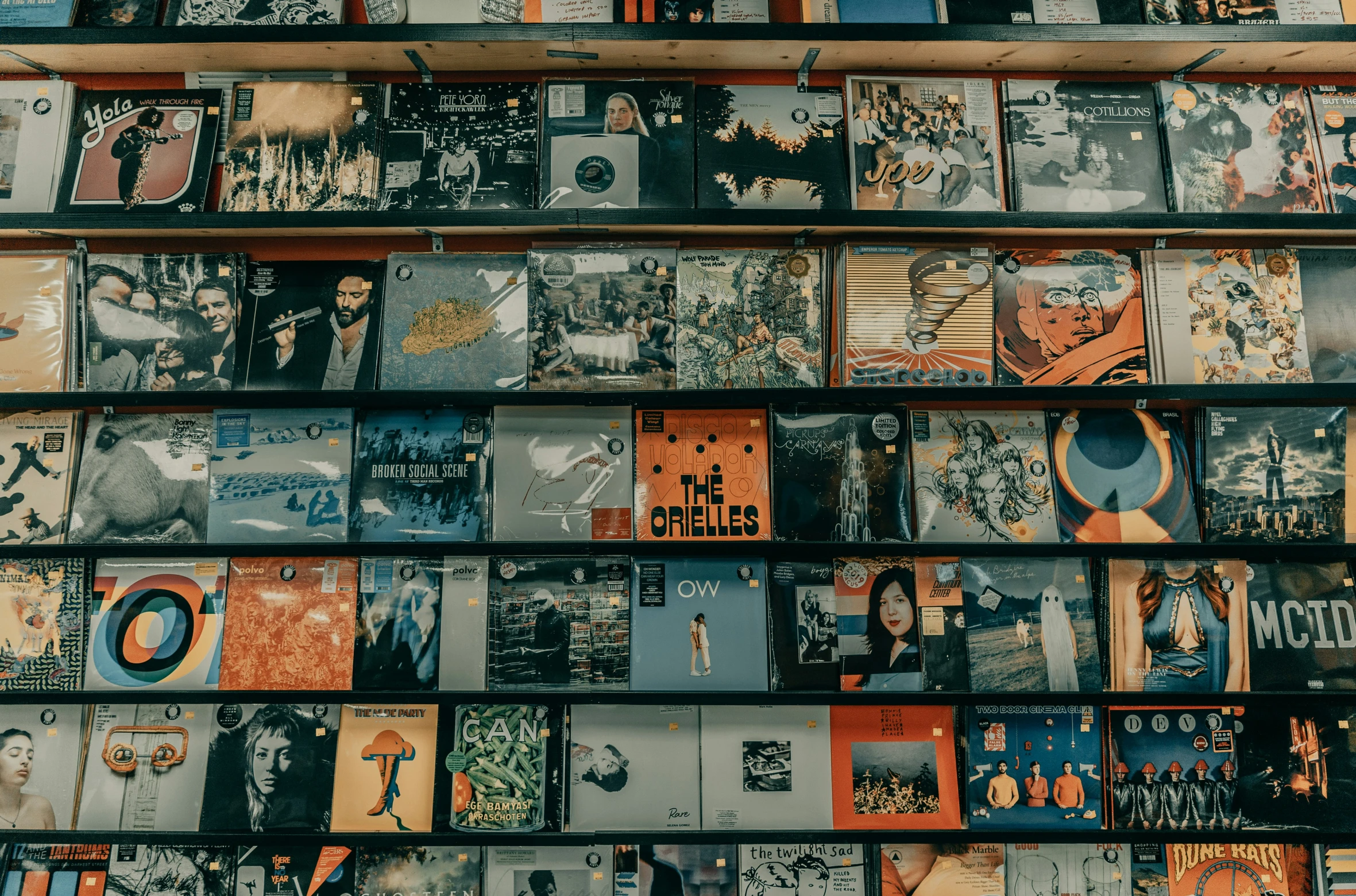 books are stacked up against a wall covered in pictures