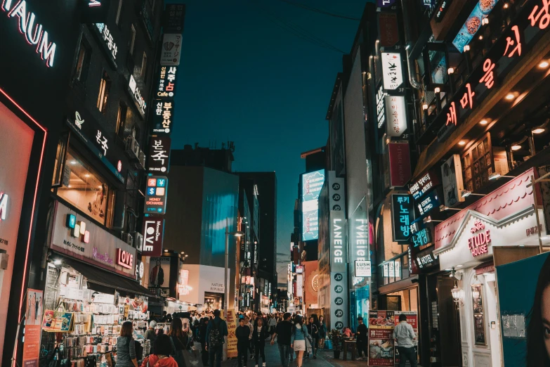 a city street filled with neon lit buildings