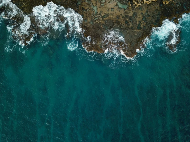 the water is very blue and foamy next to the shore