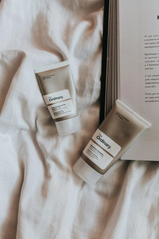 two items of skin care sitting on top of a white sheet