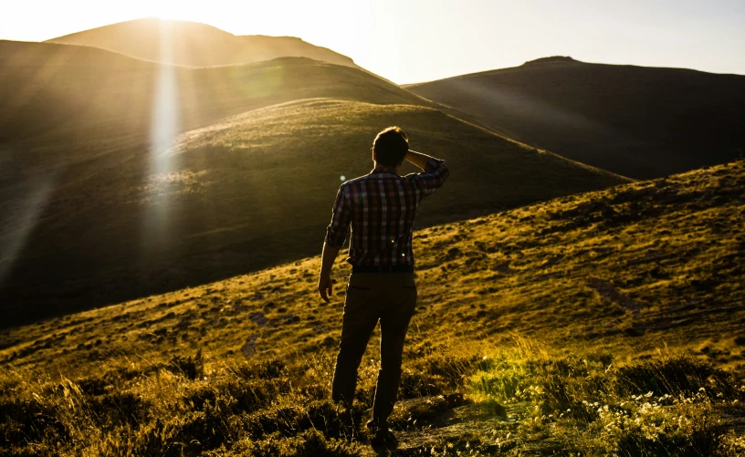 the man is walking up a hill alone