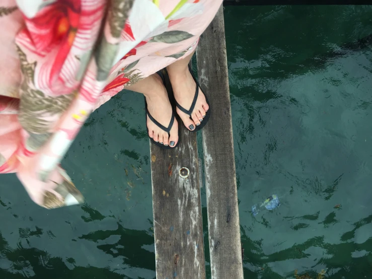 a person standing on a dock next to the water