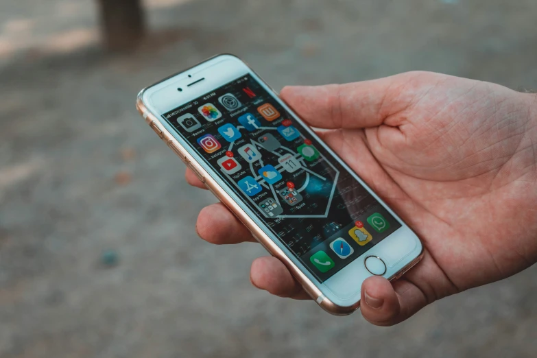 a person is holding up an iphone with icons on it