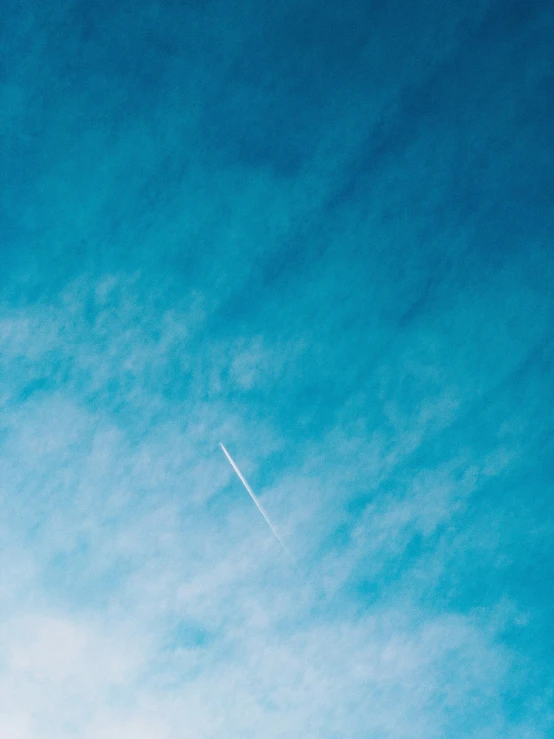 an airplane flying through a blue sky with clouds