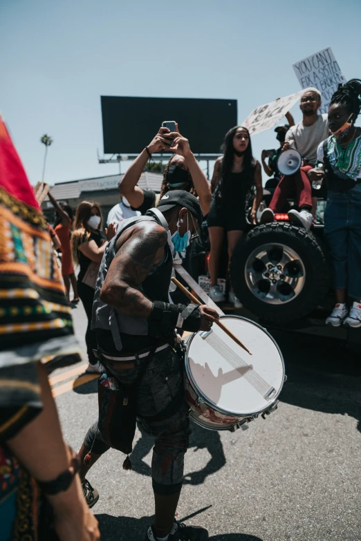 a man wearing a costume and playing drums and a cell phone