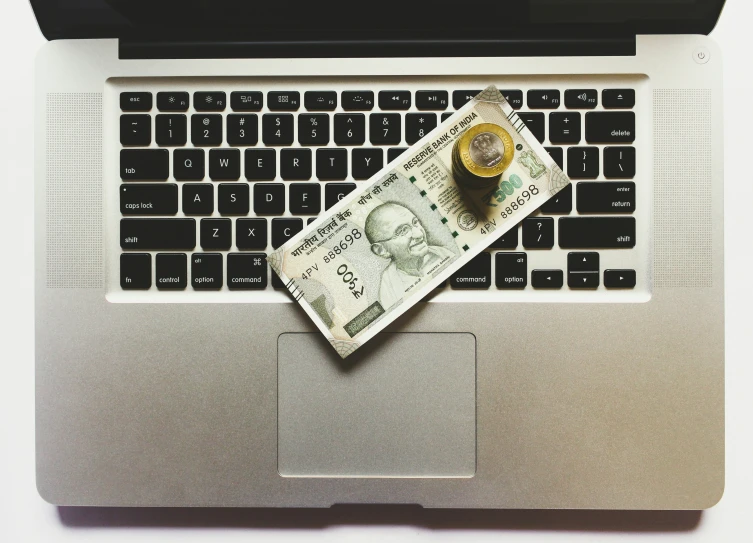 a dollar bill sitting on top of a laptop keyboard