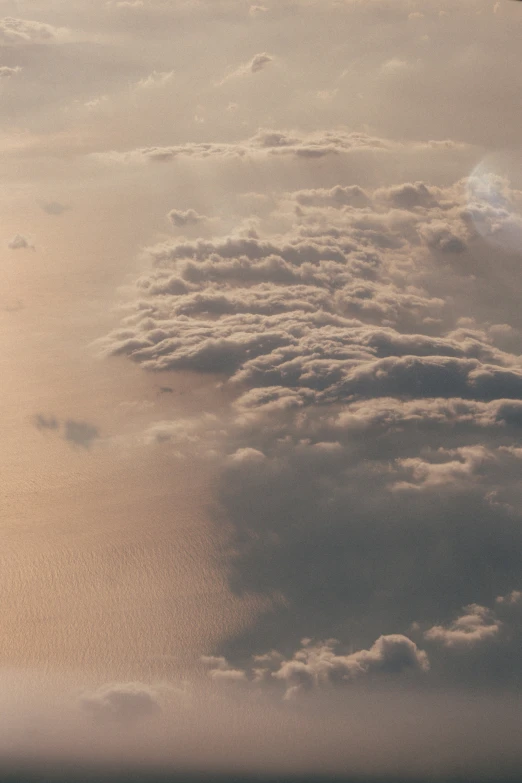 an airplane with some clouds on it flying in the sky