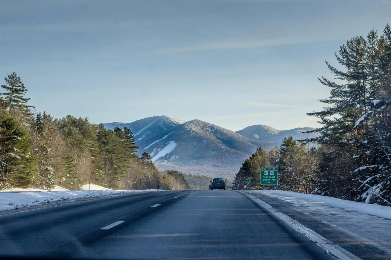 a view of a highway in the mountains and trees