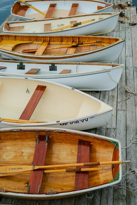 a rowboat lined up on a dock with canoes