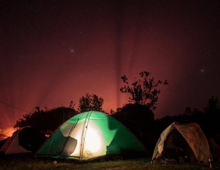 the couple of tents are illuminated by a bright light