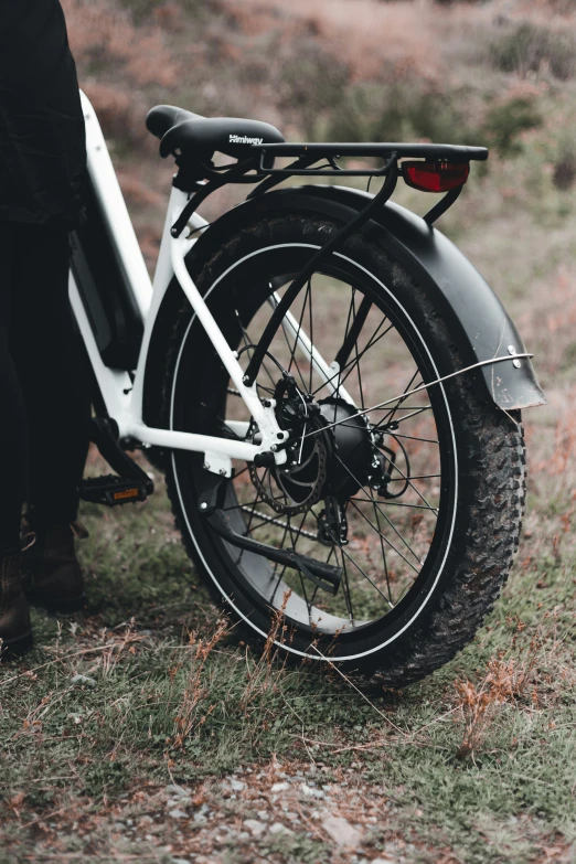 a person stands near a bike with a tire