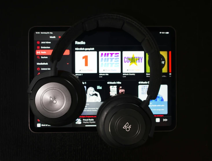 some black headphones sitting on top of a tablet