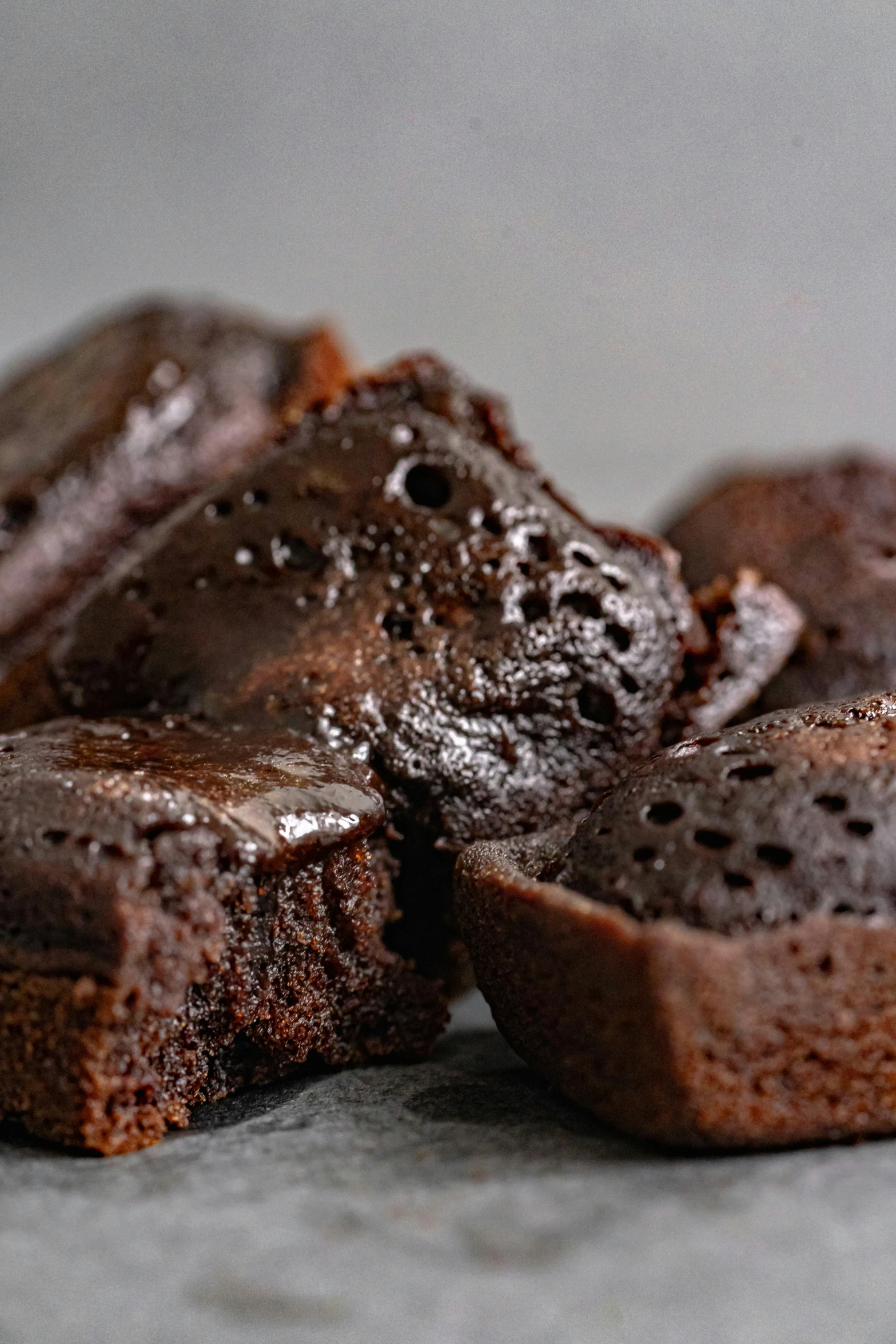 chocolate brownies in a pile that is covered with melted caramel