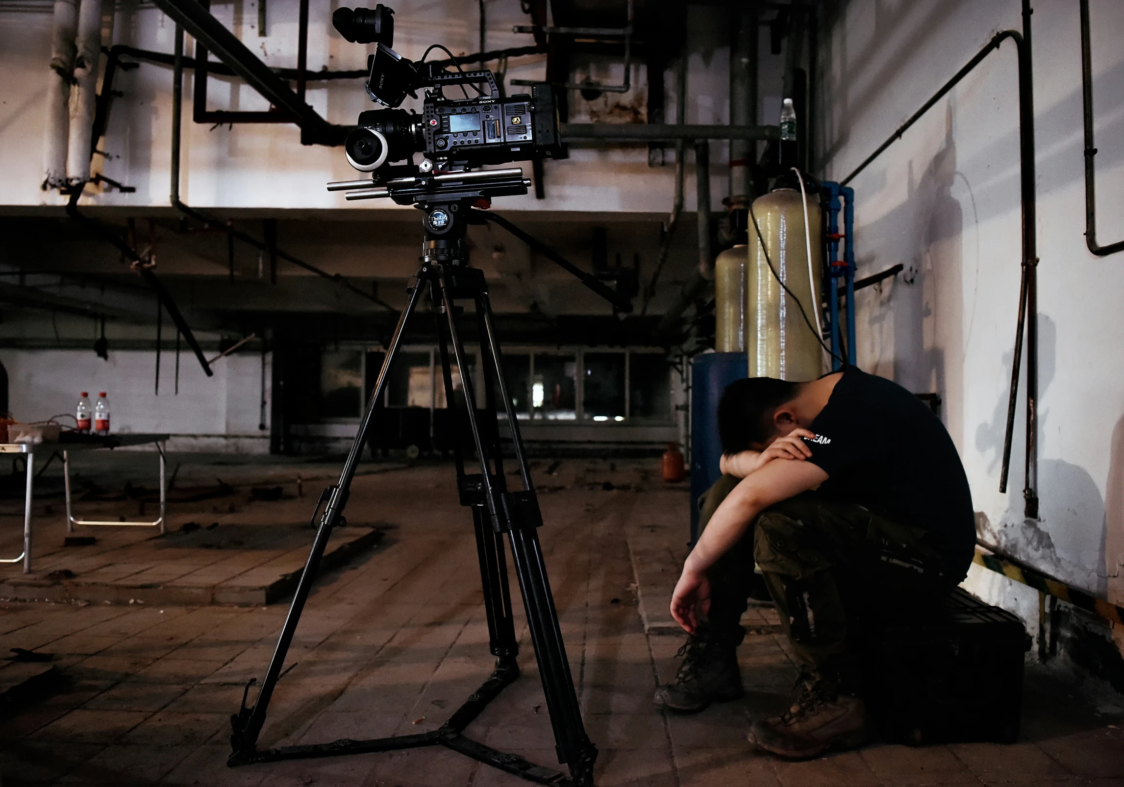 a man is crouching down near a camera