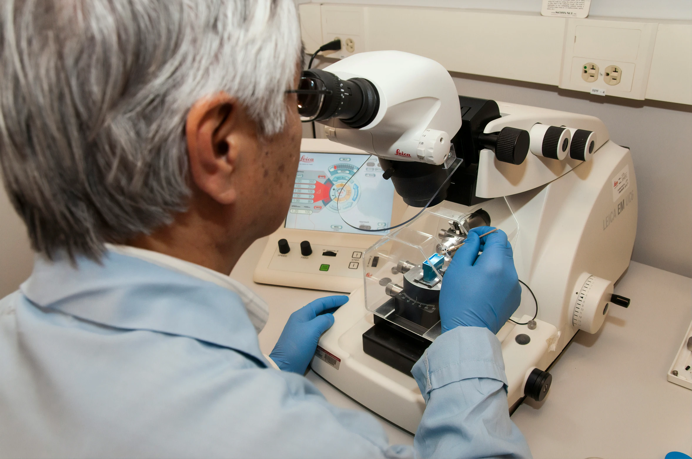 a man is looking through an microscope with a camera