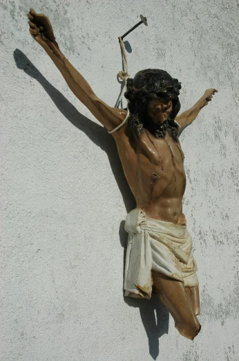 a statue of jesus, on the side of a building