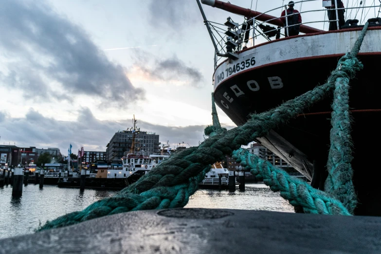 rope wrapped around boat docked in a harbor