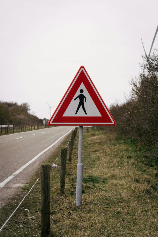 a pedestrian crossing sign is by the side of the road