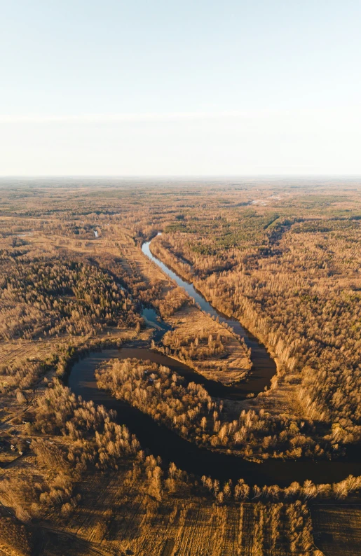 an aerial po of brown grass and a river