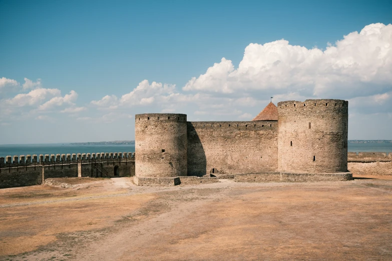 a large stone castle with a clock tower near the beach