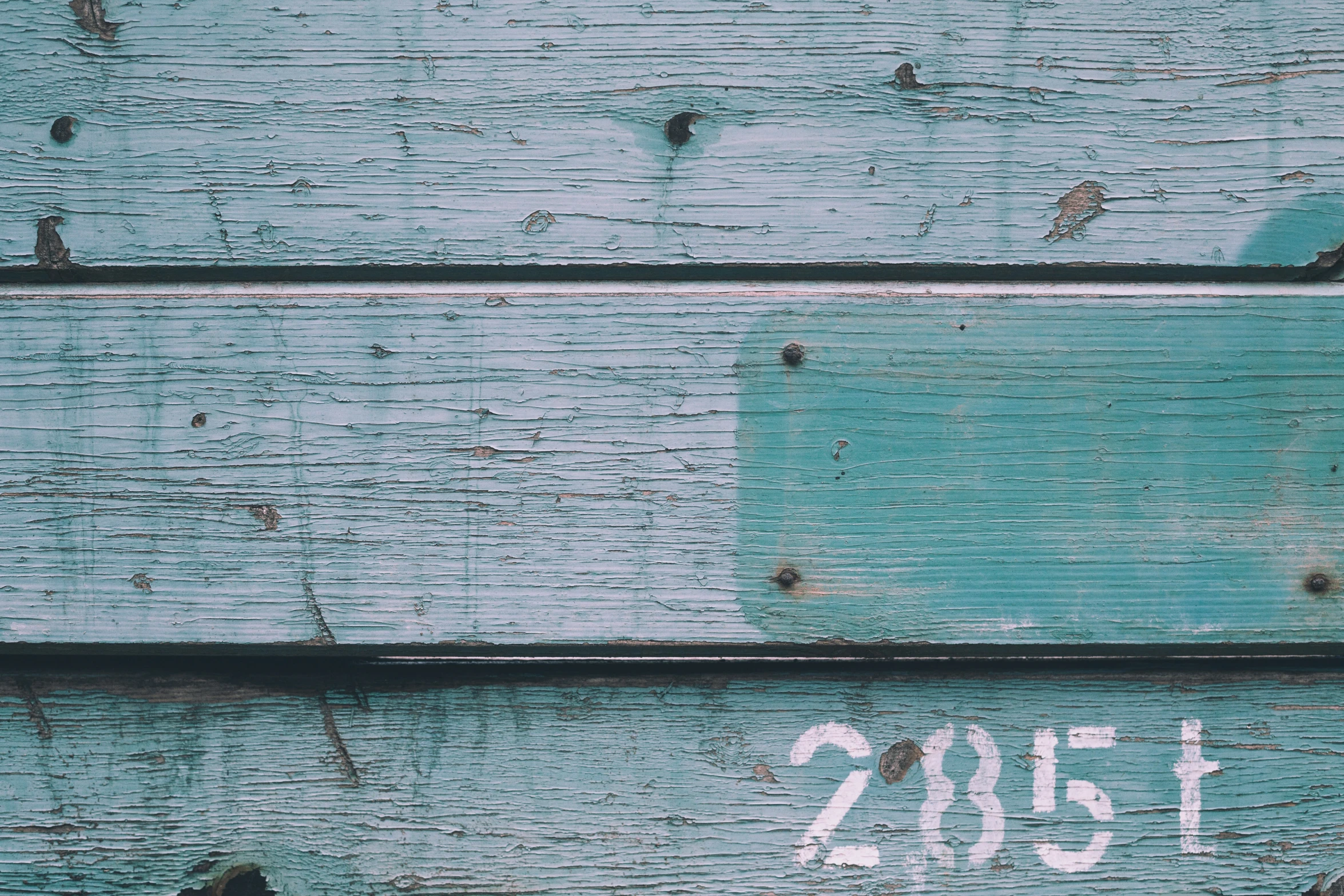 an old wooden plank with some faded paint on it