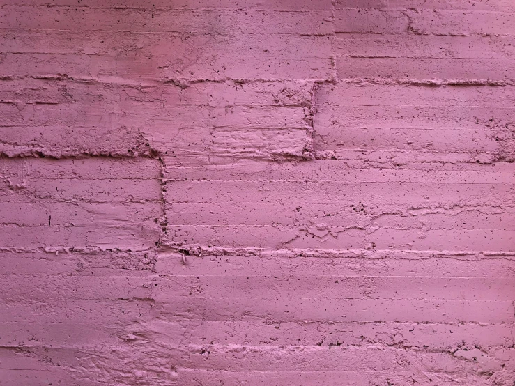 a pink brick wall with two bricks that are different sized and color