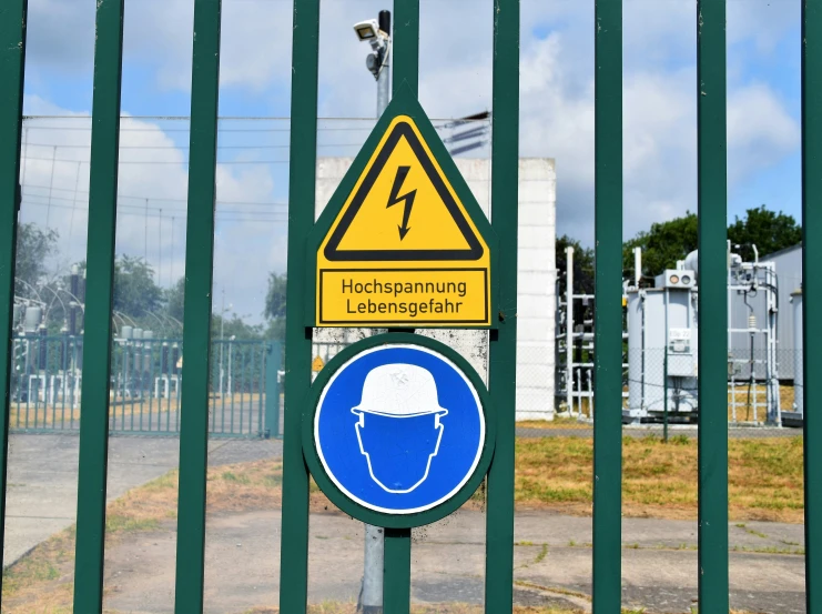 a road sign on an electric fence indicating drivers and the area it is important to be in