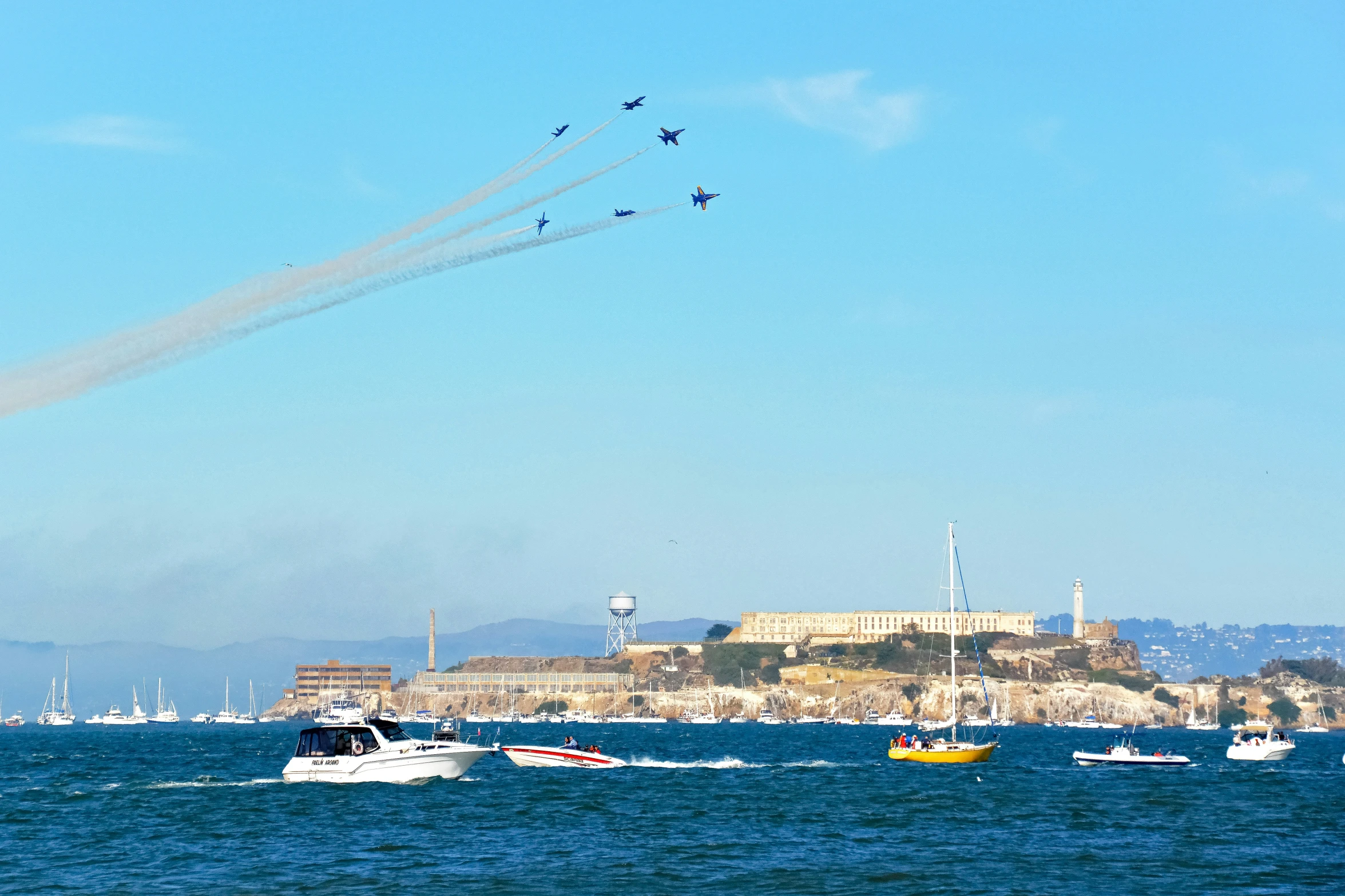 the airplanes are flying in formation across the water