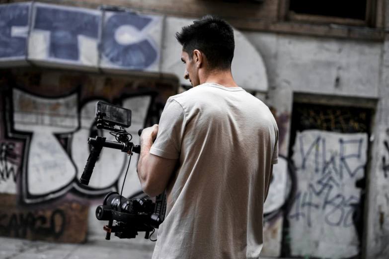 a man with a camera set up to record graffiti