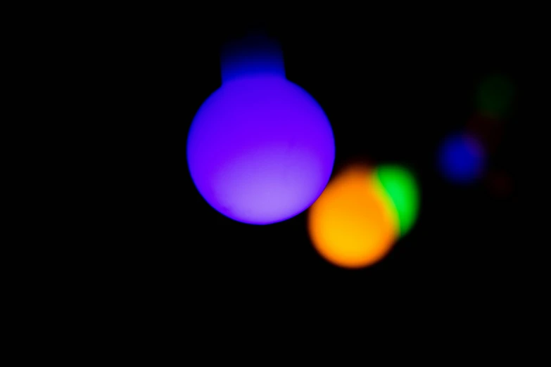 a stop light with the focus on it's colorful spheres
