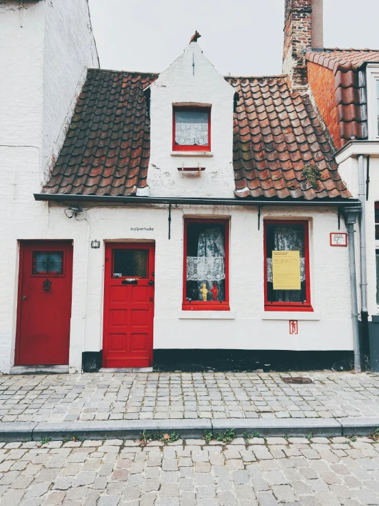 a street scene with focus on the red door and white building