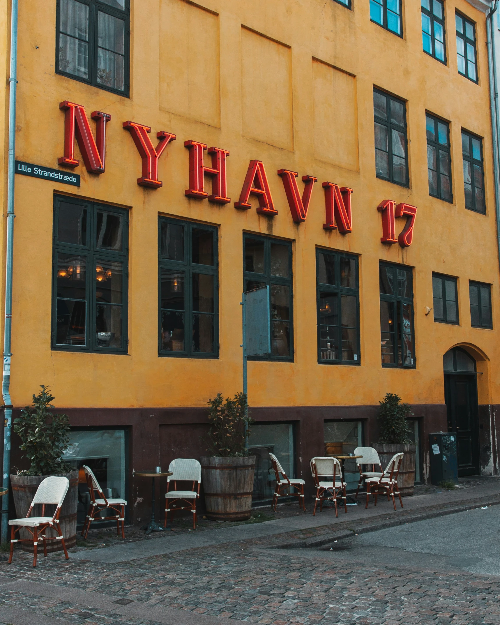 chairs line the cobblestone streets of a small city