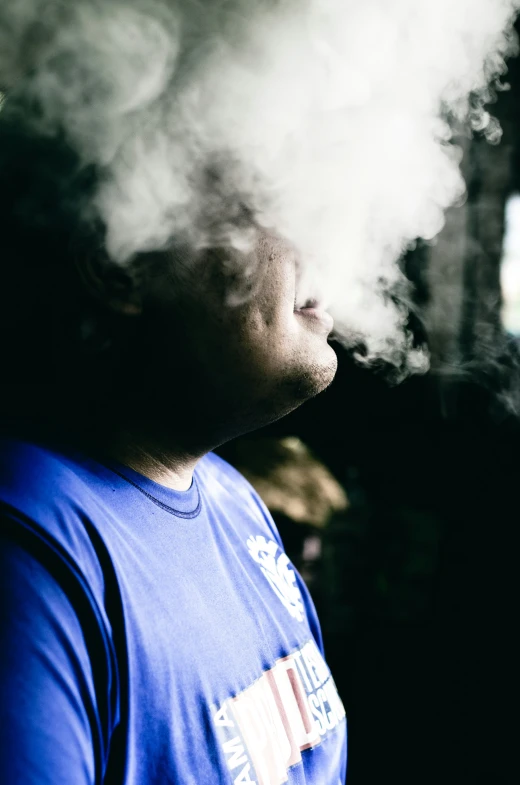 a man is smoking a pipe while sitting in the middle of the room